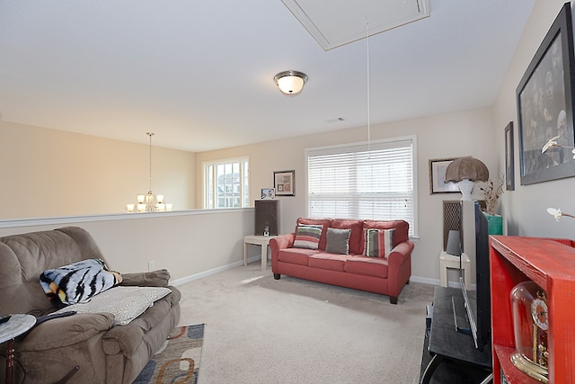 carpeted living room with a chandelier, visible vents, attic access, and baseboards