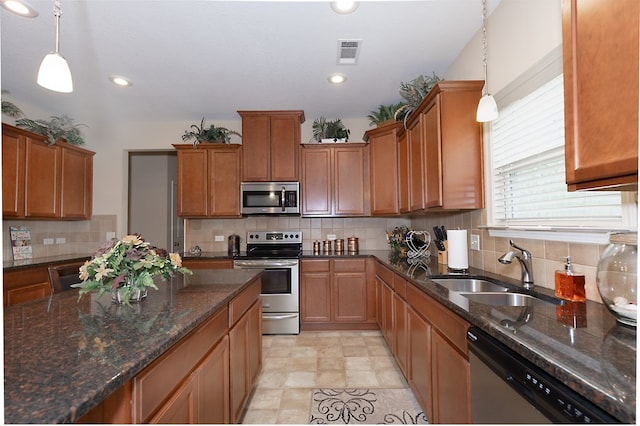 kitchen featuring appliances with stainless steel finishes, a sink, visible vents, and brown cabinets