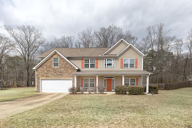 traditional home featuring an attached garage, fence, stone siding, concrete driveway, and a front lawn