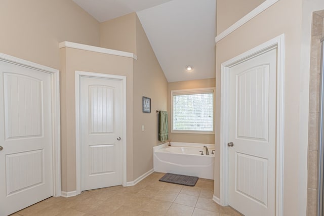 bathroom with lofted ceiling, baseboards, a bath, and tile patterned floors