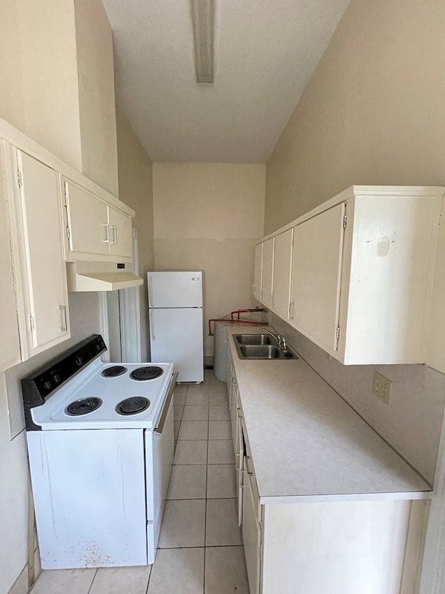 kitchen featuring sink, white cabinets, light tile patterned flooring, and white appliances