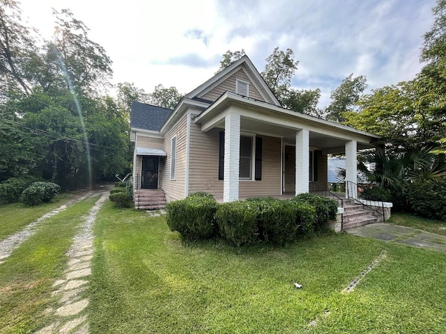 view of front of house with covered porch and a front lawn