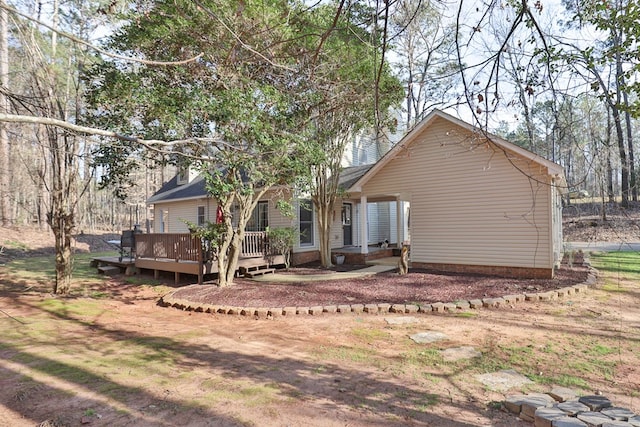 rear view of house featuring a wooden deck