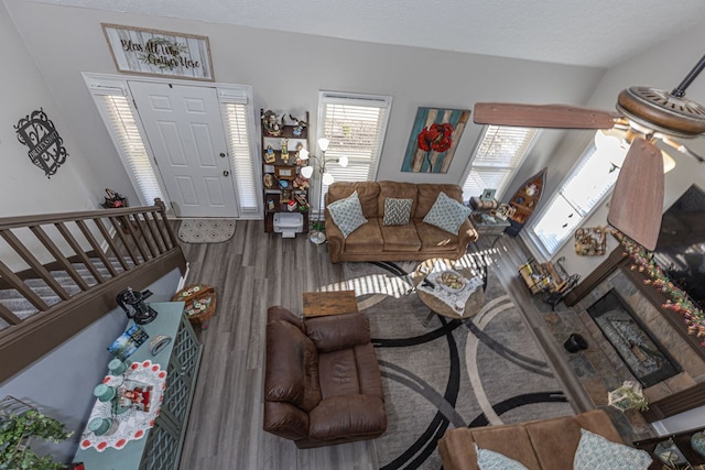 living area with stairs, wood finished floors, and a textured ceiling