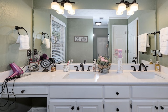 full bath featuring a sink, visible vents, a notable chandelier, and double vanity