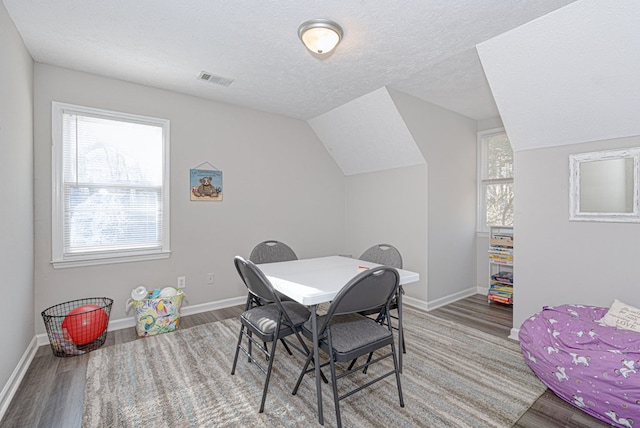 dining area featuring plenty of natural light, a textured ceiling, and wood finished floors