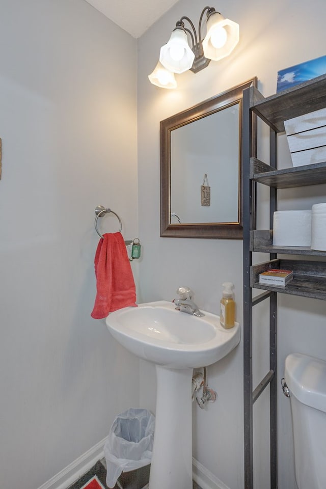 bathroom with toilet and baseboards