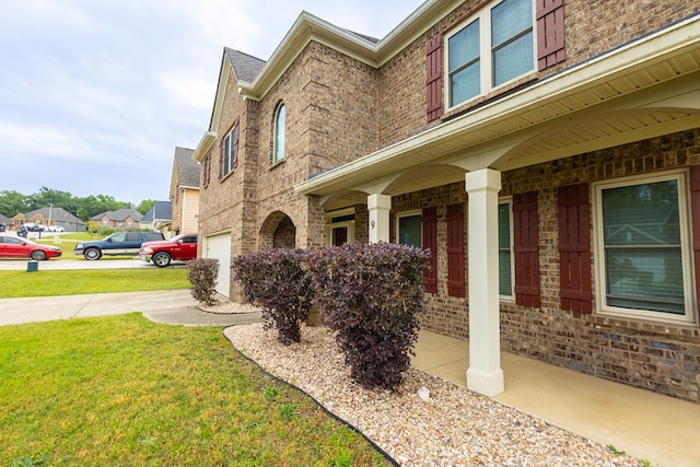 9 Red Maple St, Phenix City, AL 36869 - view of home's exterior with brick siding, a yard, a garage, and a porch