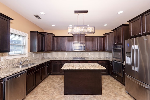 9 Red Maple St, Phenix City, AL 36869 - kitchen featuring stainless steel appliances, a kitchen island, a sink, dark brown cabinets, and light stone counters