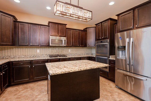 9 Red Maple St, Phenix City, AL 36869 - kitchen featuring stainless steel appliances, dark brown cabinetry, a center island, decorative backsplash, and light stone counters