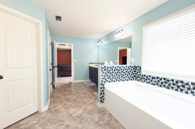 9 Red Maple St, Phenix City, AL 36869 - bathroom featuring vanity, a bath, connected bathroom, and baseboards