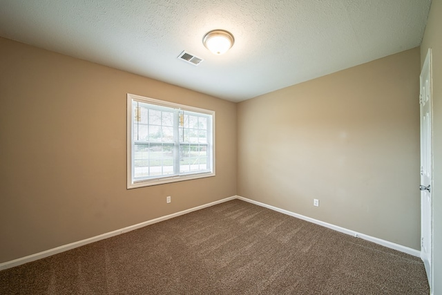 empty room with carpet and a textured ceiling