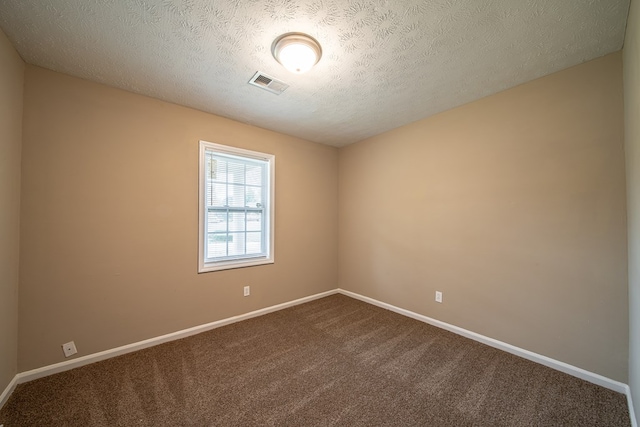 unfurnished room with carpet flooring and a textured ceiling