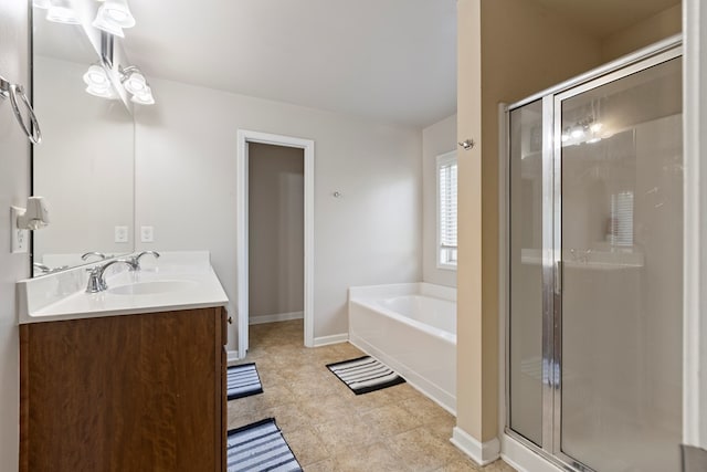 bathroom with double vanity, a bath, baseboards, and a stall shower