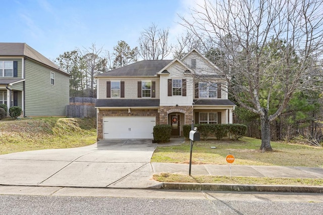 traditional-style house with a garage, stone siding, concrete driveway, and a front yard