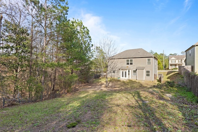 back of property featuring a lawn and fence