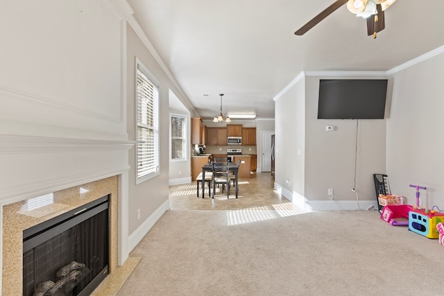 living area with crown molding, a fireplace, baseboards, and light carpet