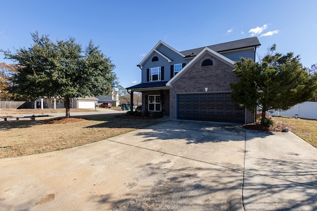 traditional-style house with a garage, fence, concrete driveway, and brick siding