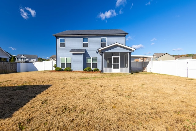 rear view of property featuring a sunroom, a fenced backyard, and a yard