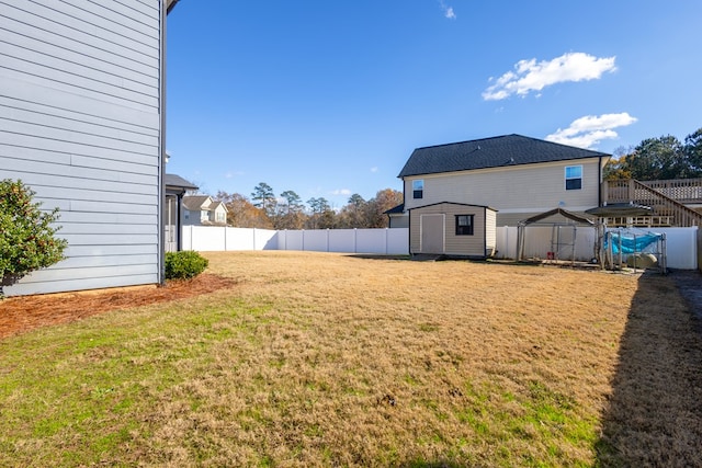 view of yard featuring an outbuilding, a fenced backyard, and a storage shed