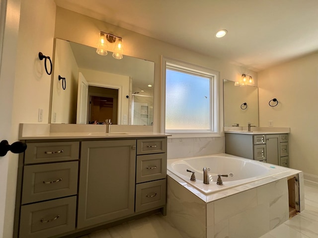 bathroom with tiled tub and vanity