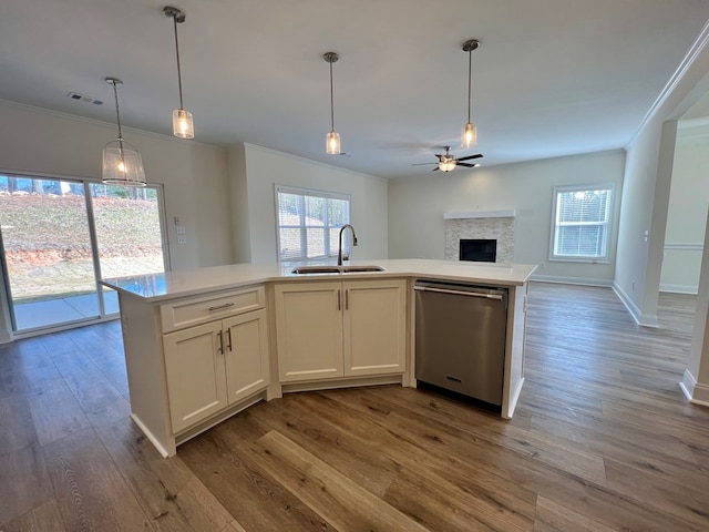 kitchen with pendant lighting, dishwasher, sink, white cabinets, and a kitchen island with sink