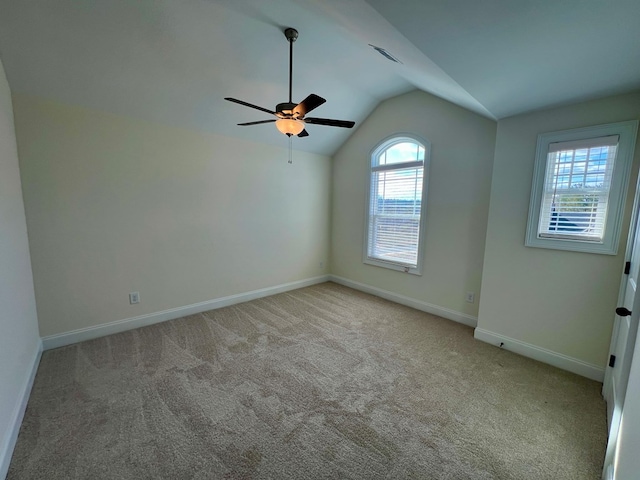 empty room with light carpet, vaulted ceiling, and ceiling fan