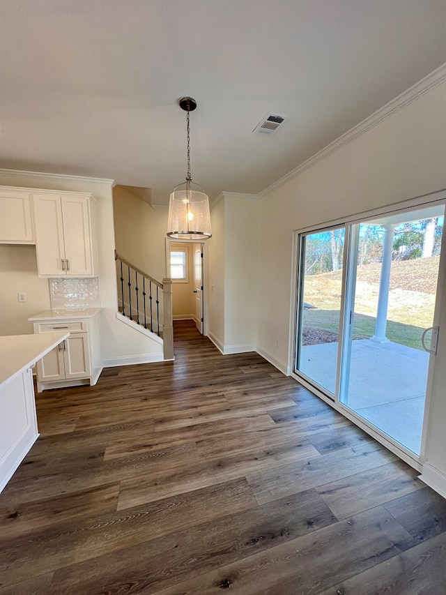 unfurnished dining area with crown molding and dark hardwood / wood-style floors