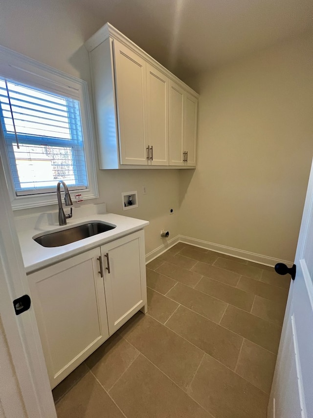 clothes washing area with washer hookup, sink, cabinets, and dark tile patterned flooring