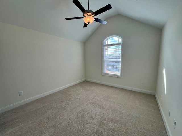 carpeted spare room featuring lofted ceiling and ceiling fan