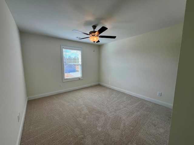 carpeted spare room featuring ceiling fan