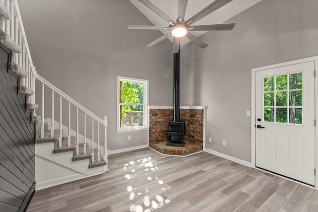 6344 Olde Towne Dr, Columbus, GA 31907 - unfurnished living room featuring a wood stove, stairway, wood finished floors, ceiling fan, and a towering ceiling