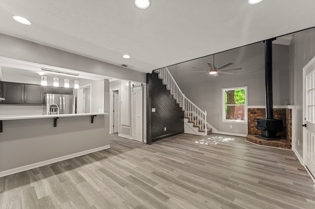 6344 Olde Towne Dr, Columbus, GA 31907 - unfurnished living room featuring a wood stove, a ceiling fan, recessed lighting, light wood-style floors, and stairway