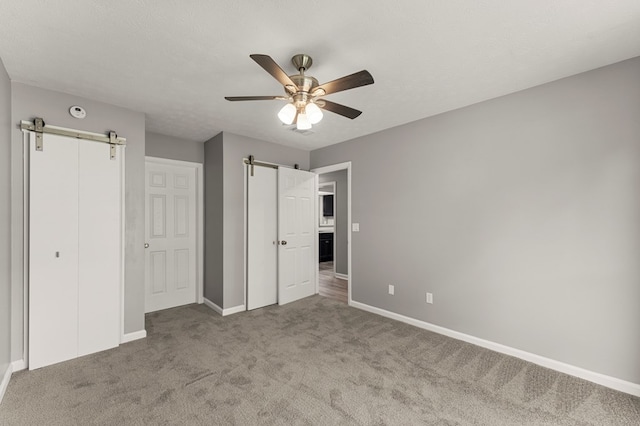 6344 Olde Towne Dr, Columbus, GA 31907 - unfurnished bedroom featuring a barn door, carpet flooring, a ceiling fan, and a closet