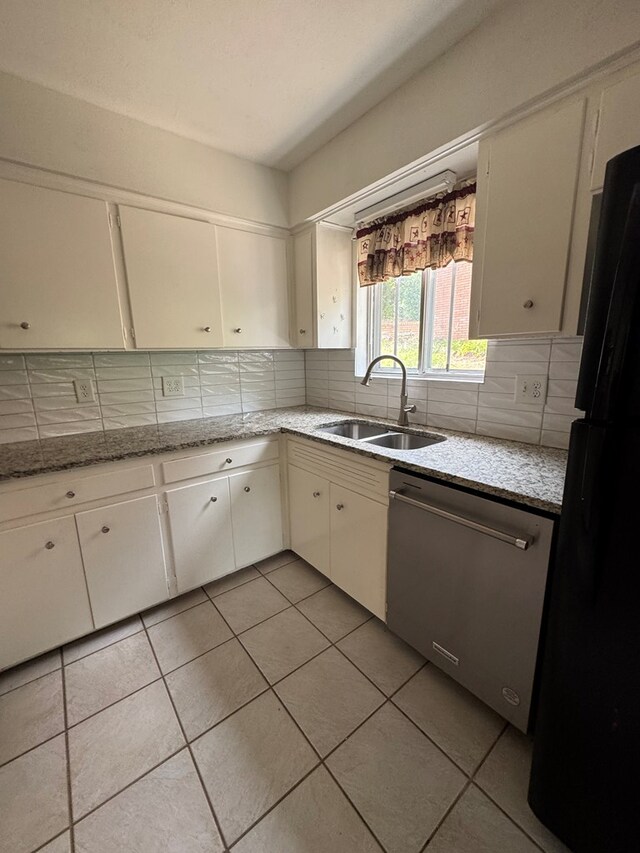 3328 College Ave, Columbus, GA 31907 - kitchen with stainless steel dishwasher, freestanding refrigerator, backsplash, light tile patterned floors, and white cabinets