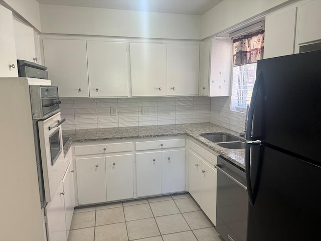 3328 College Ave, Columbus, GA 31907 - kitchen featuring freestanding refrigerator, stainless steel dishwasher, backsplash, and white cabinetry