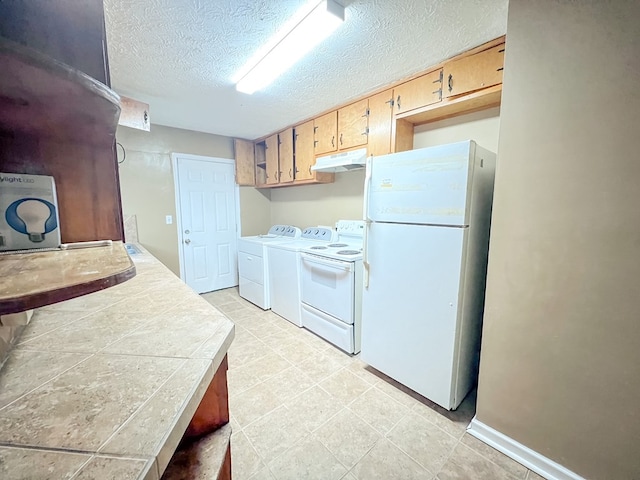 427 Bernard Dr, Columbus, GA 31903 - kitchen featuring white appliances, under cabinet range hood, washer and dryer, a textured ceiling, and tile counters