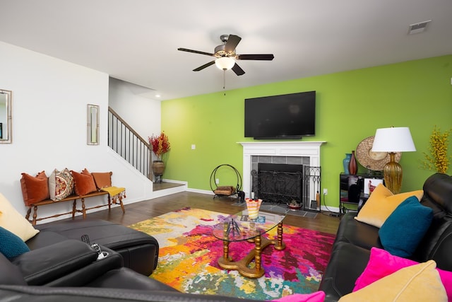 living room featuring a fireplace, ceiling fan, and dark hardwood / wood-style flooring