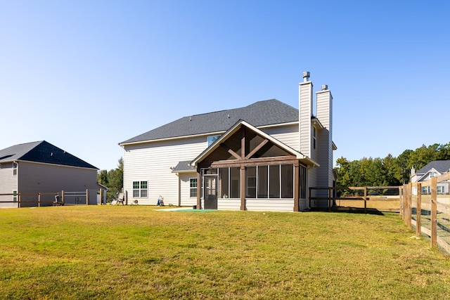 back of house with a lawn and a sunroom