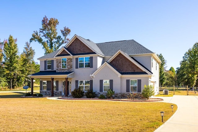 craftsman inspired home featuring central air condition unit, a front lawn, and a porch