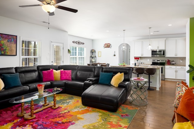 living room featuring ceiling fan and dark hardwood / wood-style floors