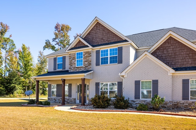 craftsman inspired home featuring covered porch and a front yard