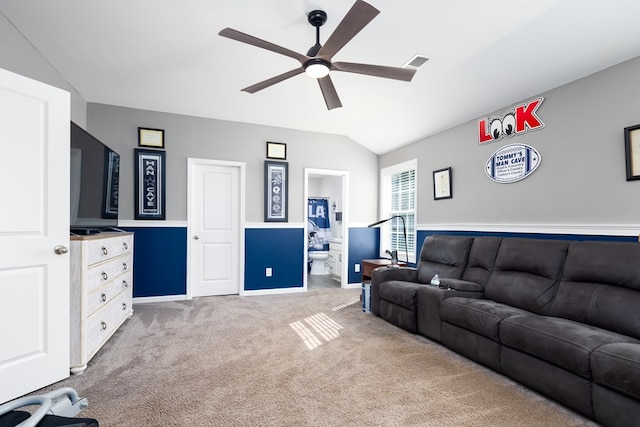 carpeted living room with ceiling fan and vaulted ceiling