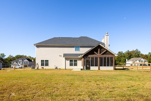 rear view of house featuring a lawn and cooling unit