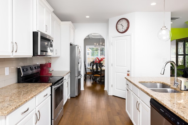 kitchen featuring pendant lighting, white cabinets, sink, dark hardwood / wood-style floors, and appliances with stainless steel finishes