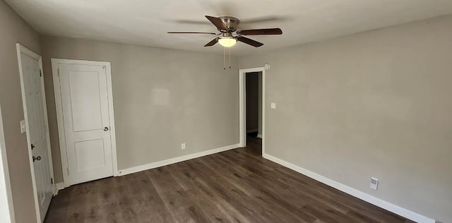 unfurnished room with dark wood finished floors, baseboards, and ceiling fan