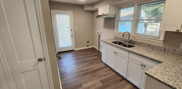 kitchen featuring a sink, visible vents, white cabinets, light stone countertops, and dark wood-style floors