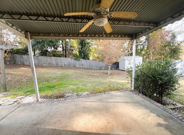 view of yard featuring ceiling fan, a storage unit, and a patio