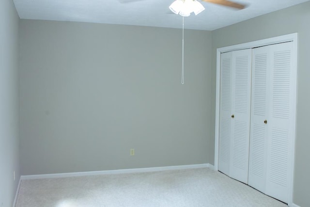 unfurnished bedroom featuring ceiling fan, light colored carpet, and a closet