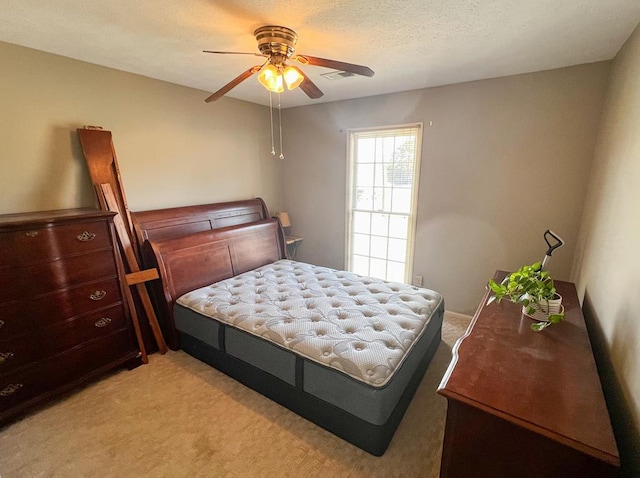 carpeted bedroom featuring a textured ceiling and ceiling fan